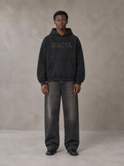 Model wearing the SM Clip Hoodie in Midnight Black, front view.