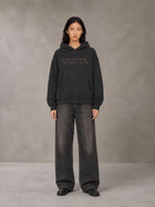 Model wearing the SM Clip Hoodie in Midnight Black, front view.