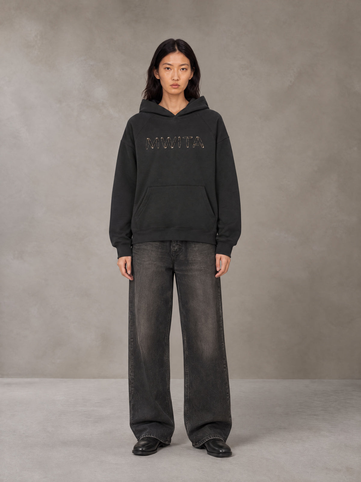 Model wearing the SM Clip Hoodie in Midnight Black, front view.