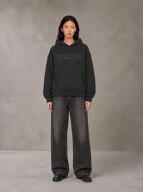 Model wearing the SM Clip Hoodie in Midnight Black, front view.