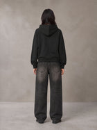 Model wearing the SM Clip Hoodie in Midnight Black, rear view.