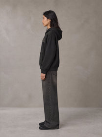 Model wearing the SM Clip Hoodie in Midnight Black, side profile.