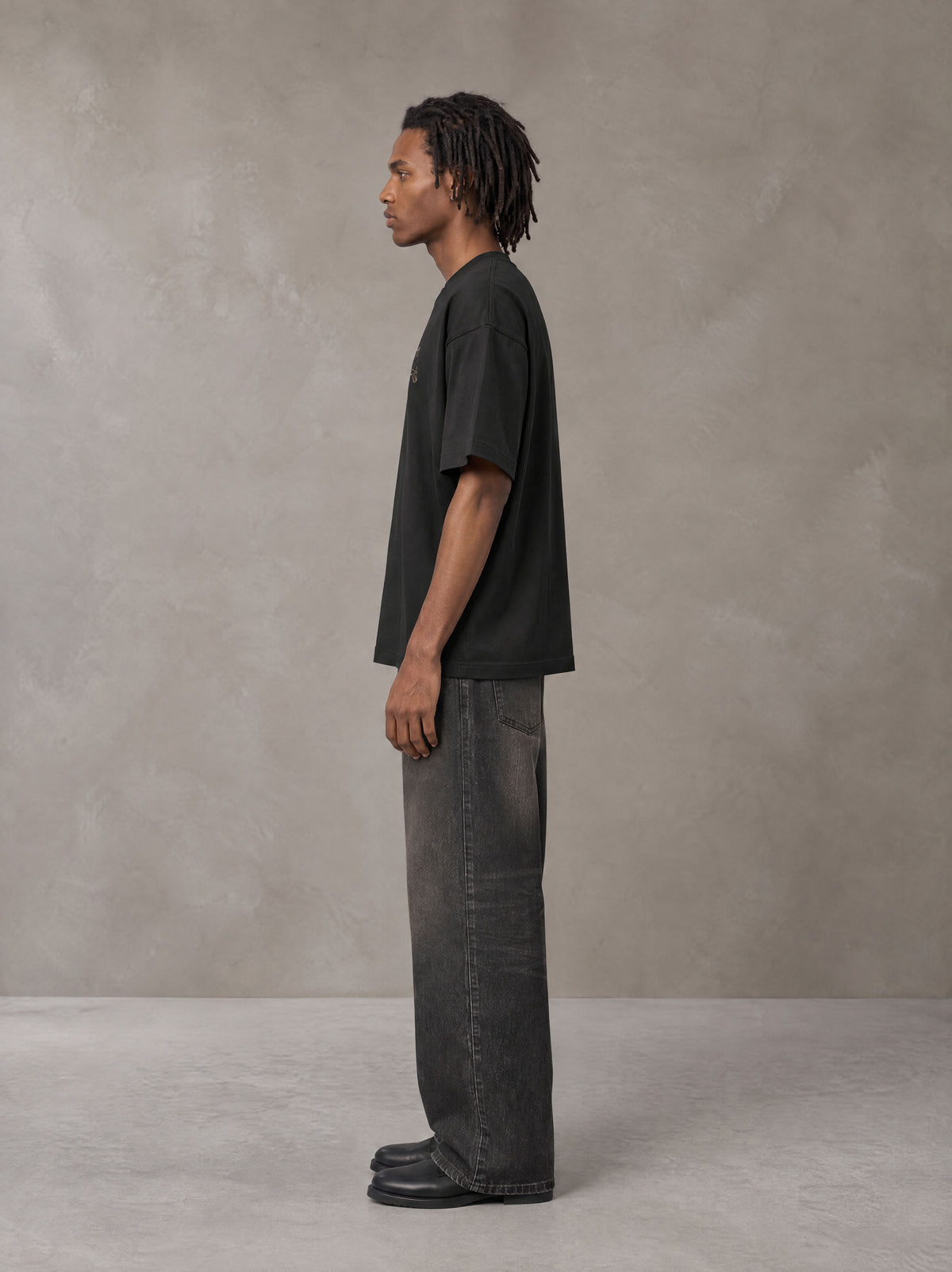 Model wearing the SM Clip T-shirt in Midnight Black, side profile.