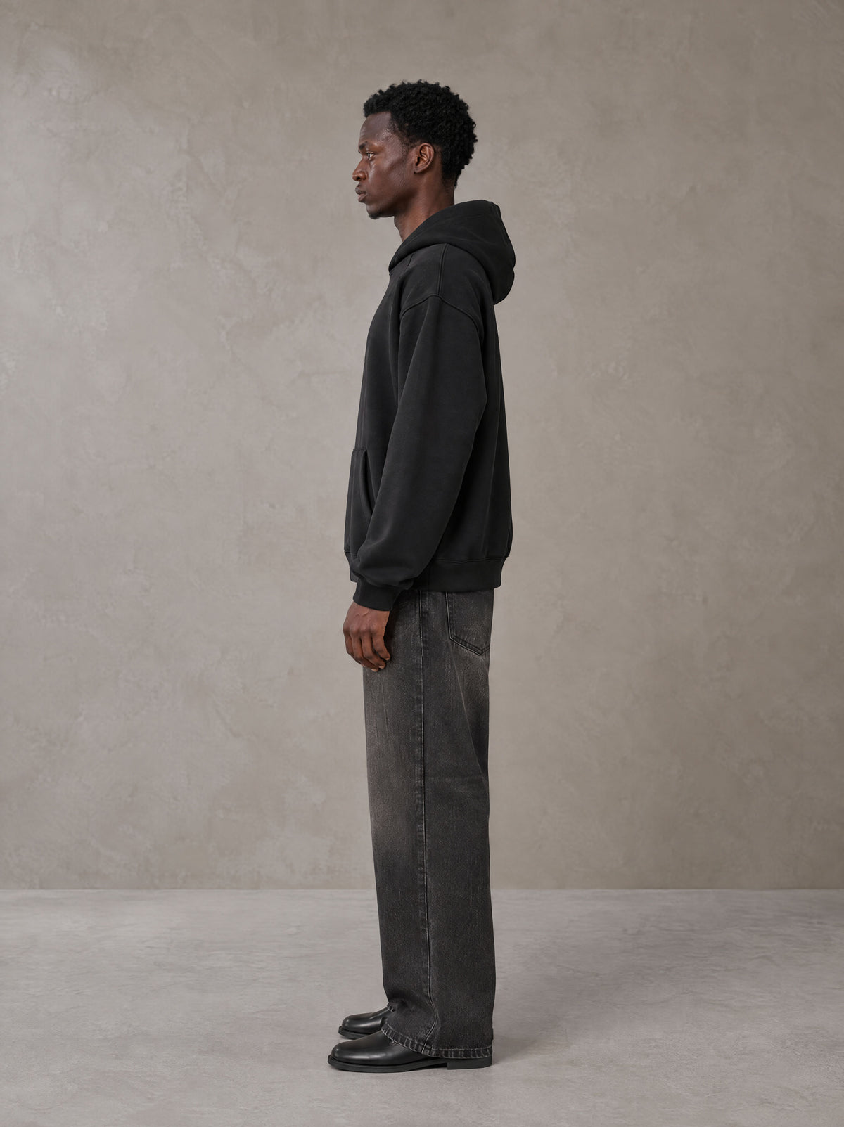 Model wearing the SM Fleur Hoodie in Midnight Black, side profile.
