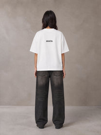 Model wearing the SM Fleur T-shirt in Lucent White, rear view.