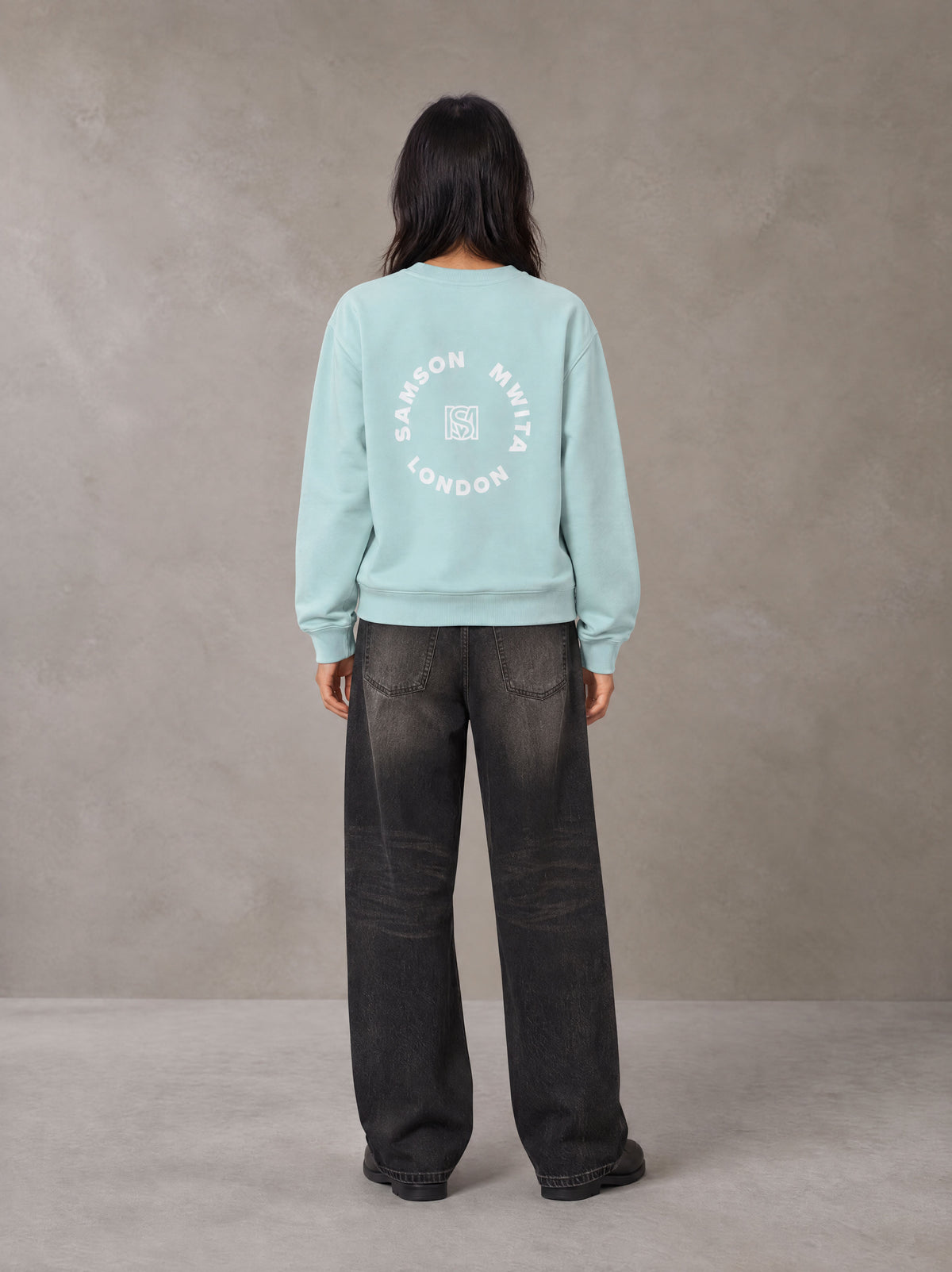 Model wearing the SM London Sweatshirt in Ice Blue, rear view.