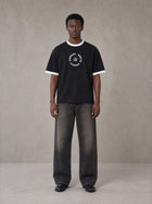 Model wearing the SM London T-shirt in Midnight Black, front view.