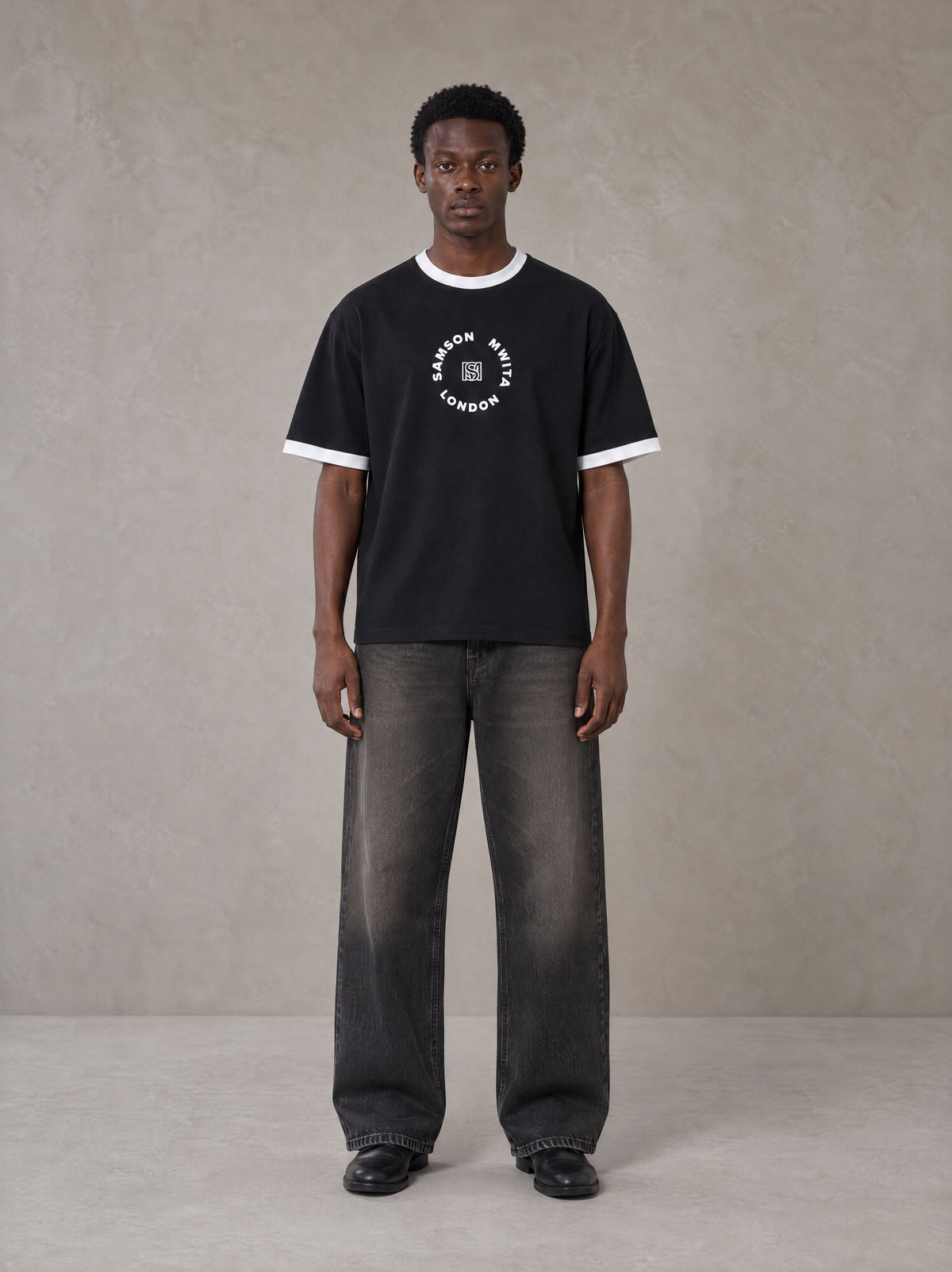 Model wearing the SM London T-shirt in Midnight Black, front view.