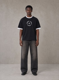 Model wearing the SM London T-shirt in Midnight Black, front view.