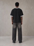 Model wearing the SM London T-shirt in Midnight Black, rear view.