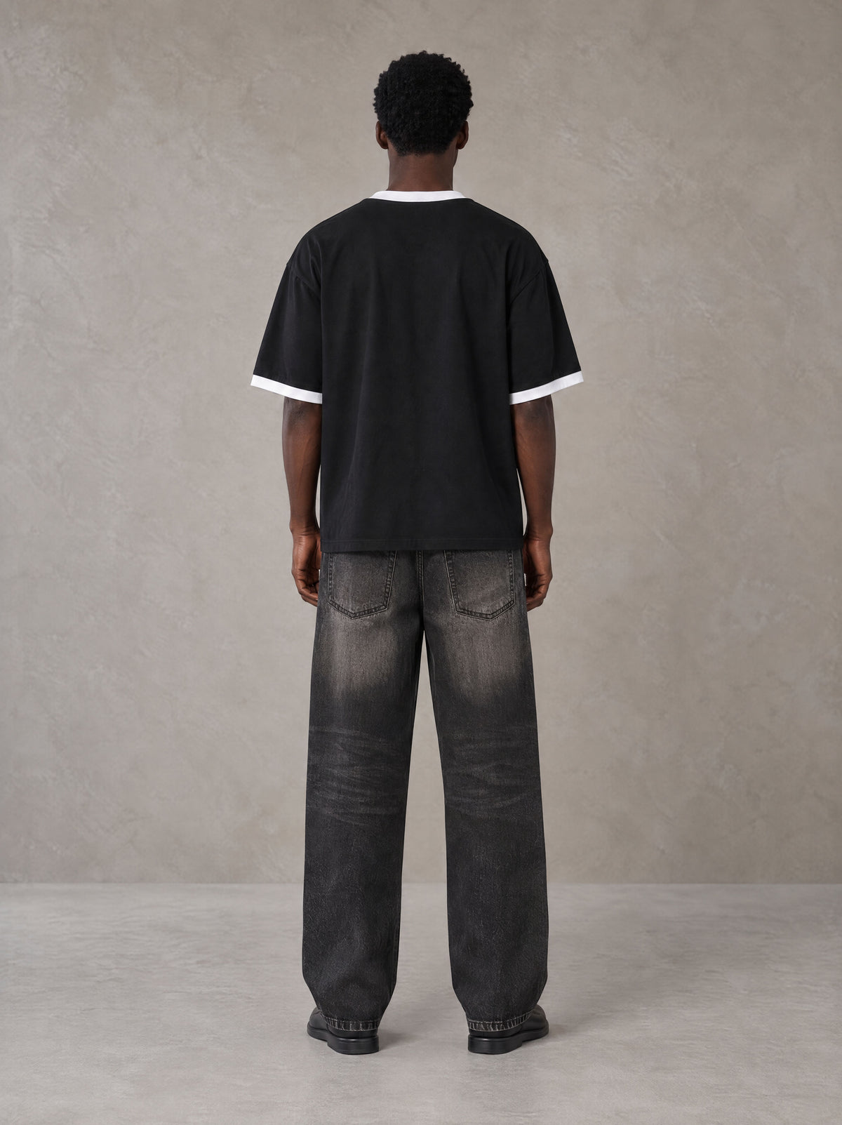 Model wearing the SM London T-shirt in Midnight Black, rear view.