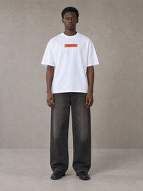 Model wearing the SM Block T-shirt in Lucent White, front view.