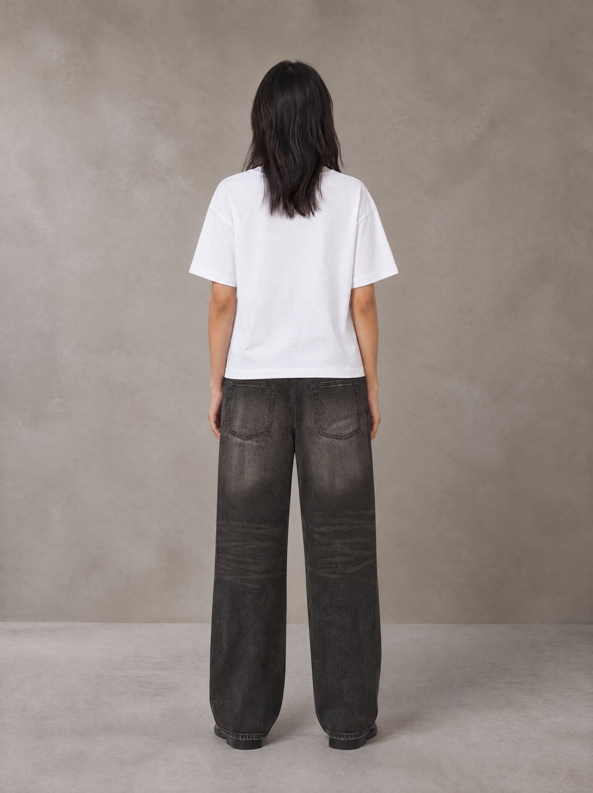 Model wearing the SM Block T-shirt in Lucent White, rear view.