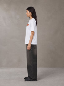 Model wearing the SM Block T-shirt in Lucent White, side profile.