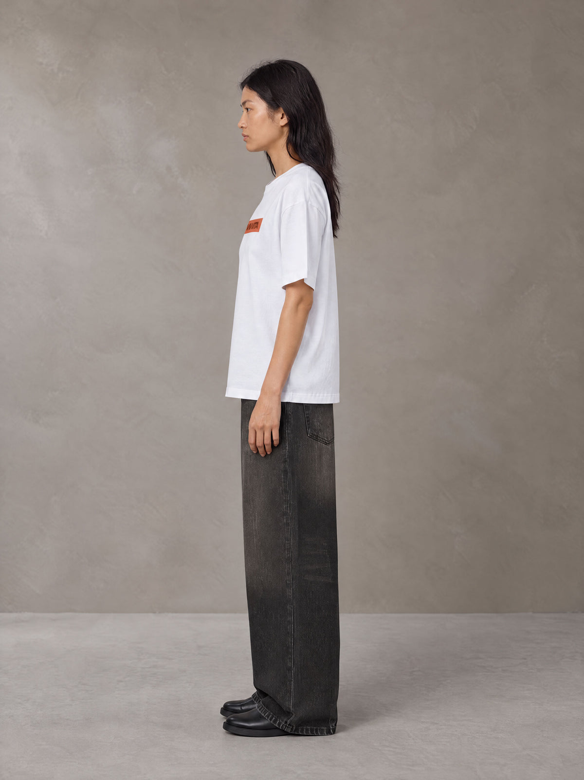 Model wearing the SM Block T-shirt in Lucent White, side profile.