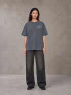 Model wearing the SM Carved Flight T-shirt in Chambray, front view.