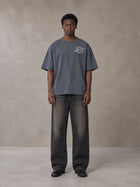 Model wearing the SM Carved Flight T-shirt in Chambray, front view.