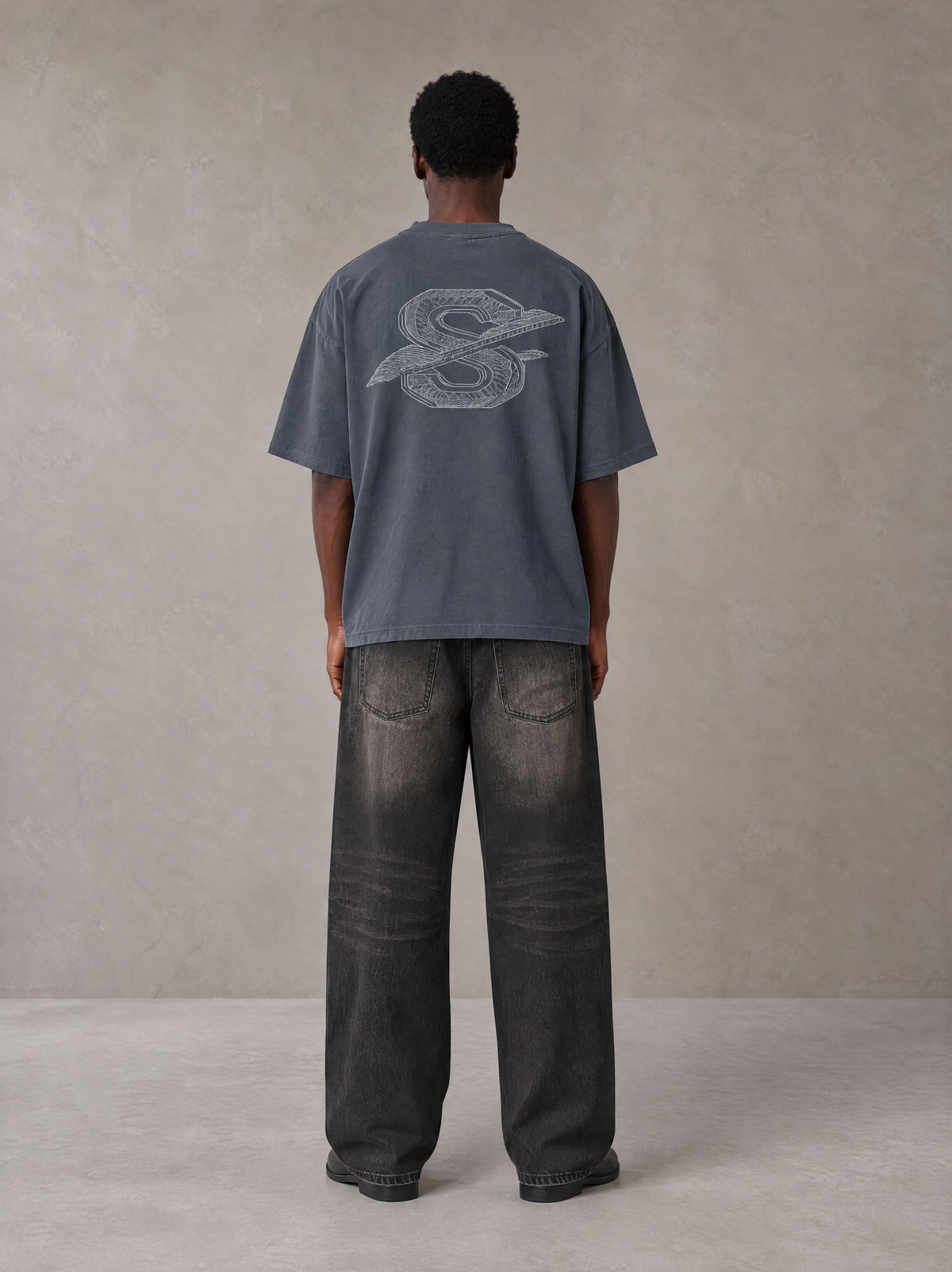 Model wearing the SM Carved Flight T-shirt in Chambray, rear view.
