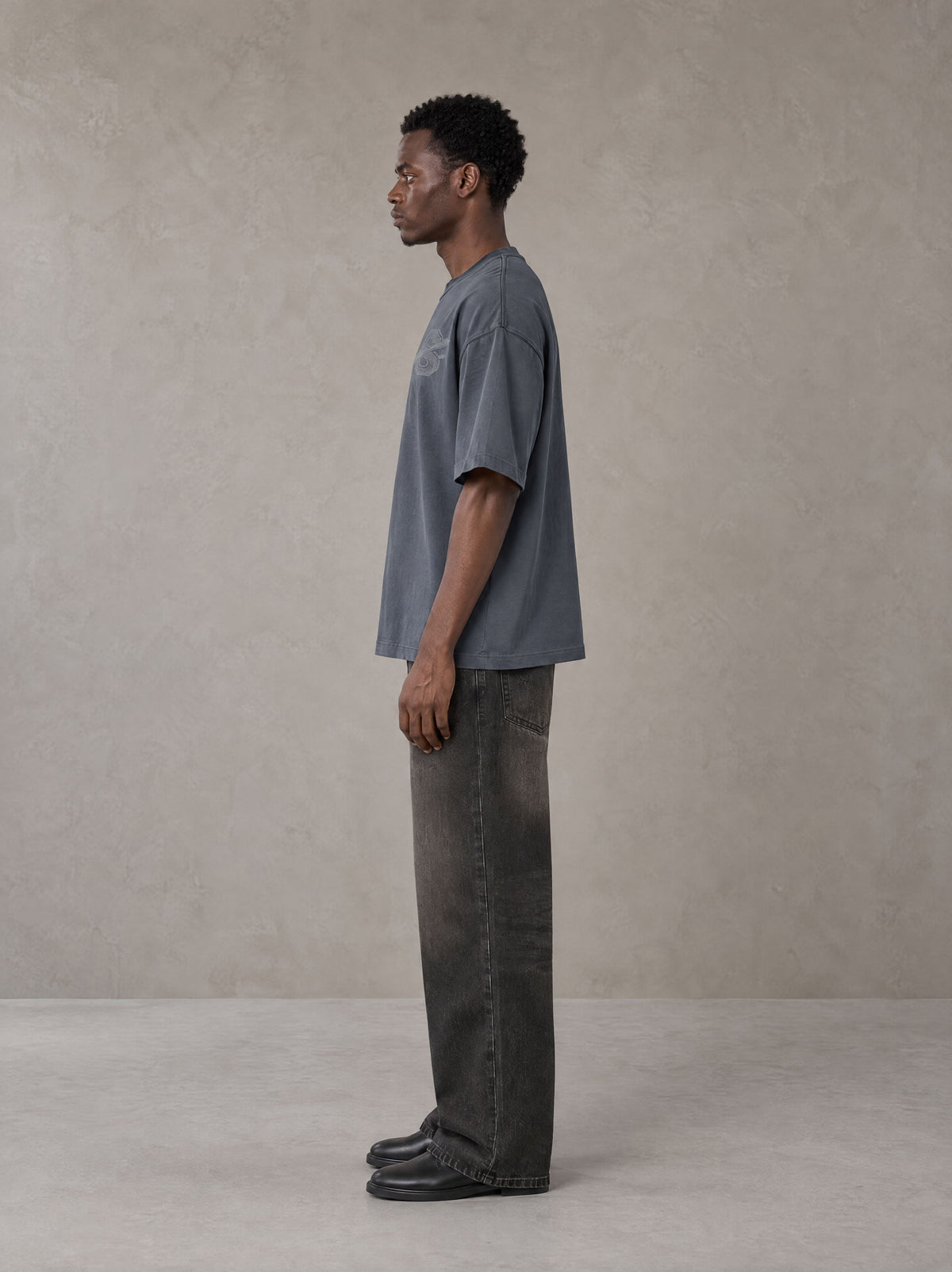 Model wearing the SM Carved Flight T-shirt in Chambray, side profile.