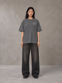Model wearing the SM Carved Flight T-shirt in Deep Charcoal, front view.