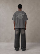 Model wearing the SM Carved Flight T-shirt in Deep Charcoal, rear view.