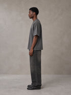 Model wearing the SM Carved Flight T-shirt in Deep Charcoal, side profile.