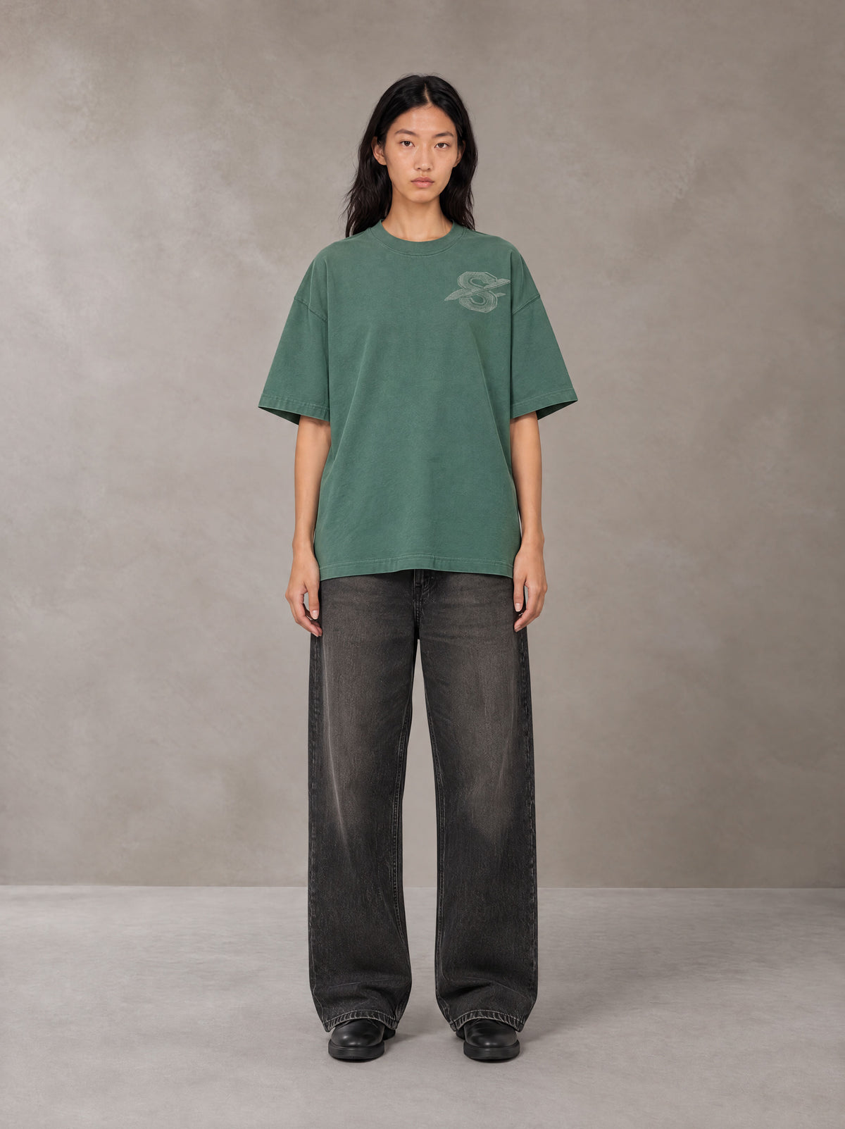 Model wearing the SM Carved Flight T-shirt in Forest Deep, front view.