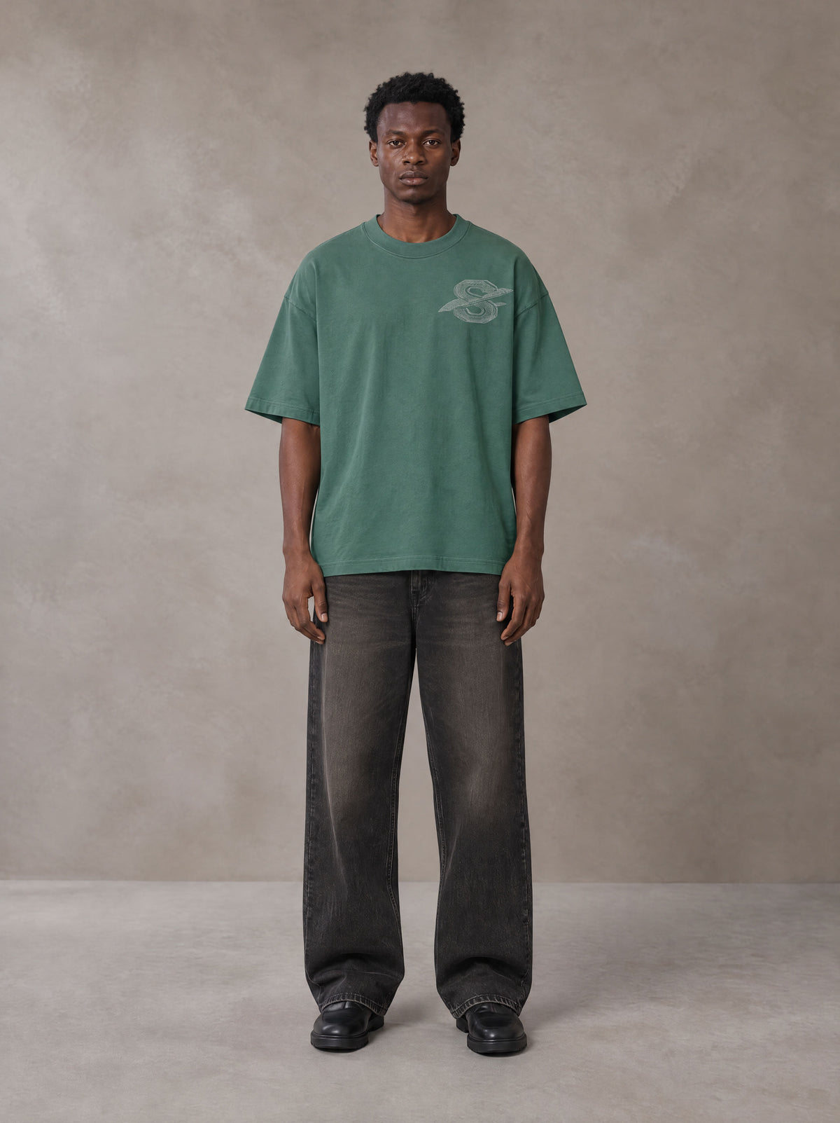 Model wearing the SM Carved Flight T-shirt in Forest Deep, front view.
