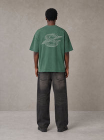 Model wearing the SM Carved Flight T-shirt in Forest Deep, rear view.