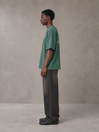 Model wearing the SM Carved Flight T-shirt in Forest Deep, side profile.