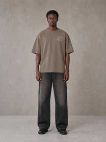 Model wearing the SM Carved Flight T-shirt in Kabul Brown, front view.