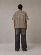 Model wearing the SM Carved Flight T-shirt in Kabul Brown, rear view.
