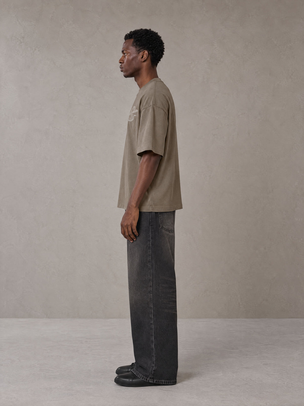 Model wearing the SM Carved Flight T-shirt in Kabul Brown, side profile.