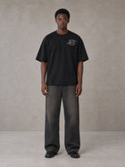 Model wearing the SM Carved Flight T-shirt in Midnight Black, front view.