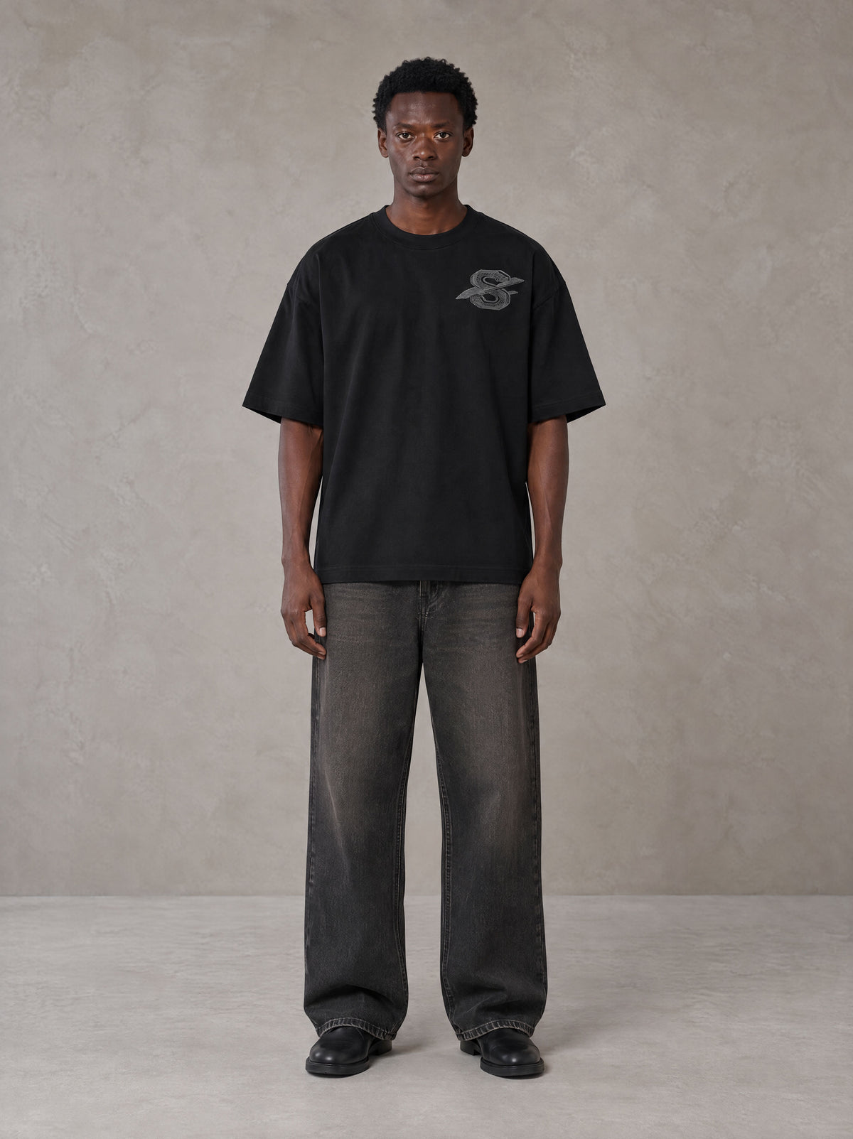 Model wearing the SM Carved Flight T-shirt in Midnight Black, front view.