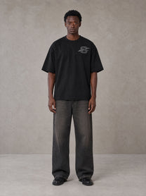 Model wearing the SM Carved Flight T-shirt in Midnight Black, front view.