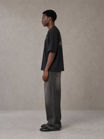 Model wearing the SM Carved Flight T-shirt in Midnight Black, side profile.