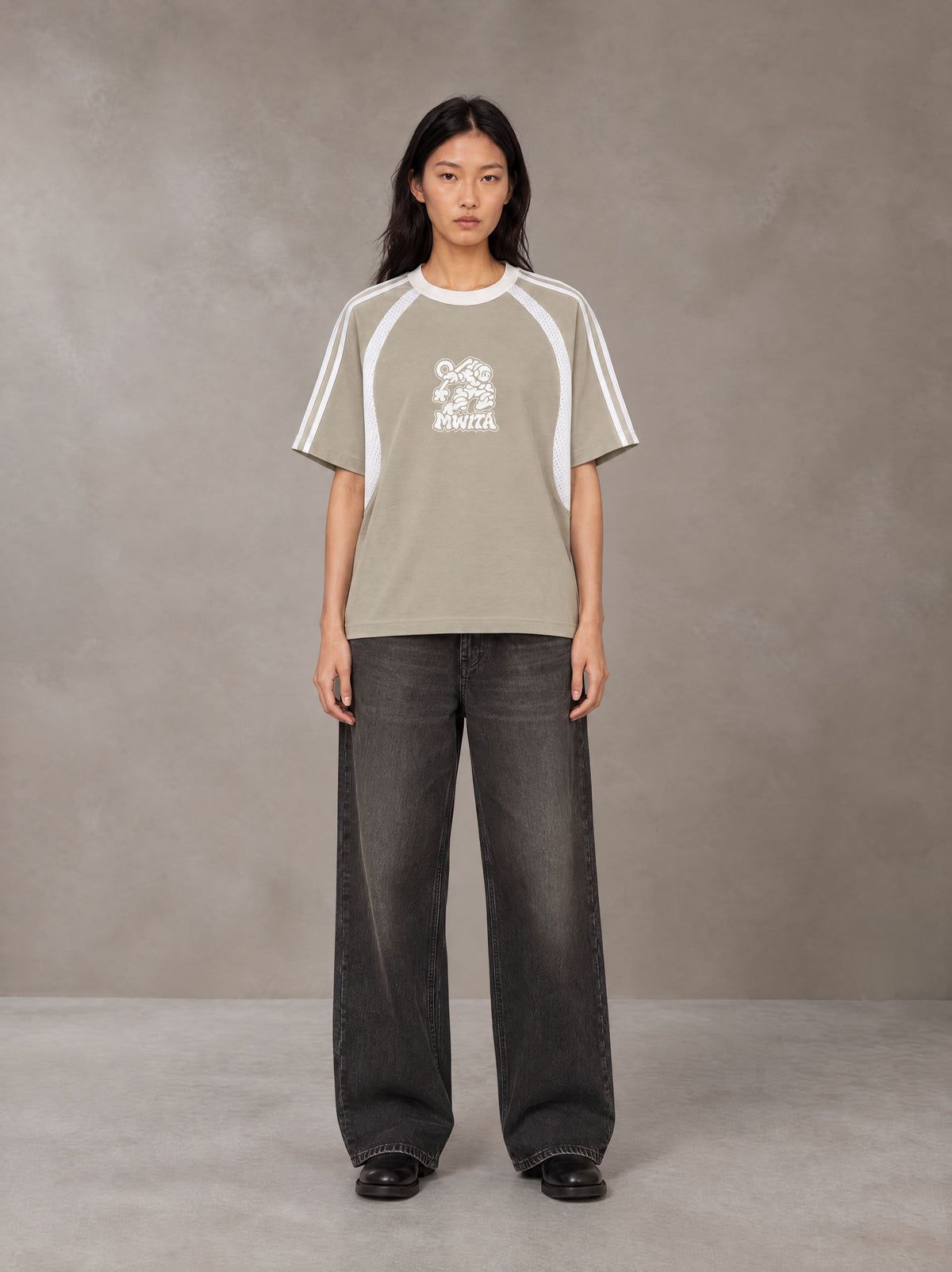 Model wearing the SM Cosmic Bloom T-shirt in Fine Sand, front view.