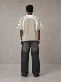 Model wearing the SM Cosmic Bloom T-shirt in Fine Sand, rear view.