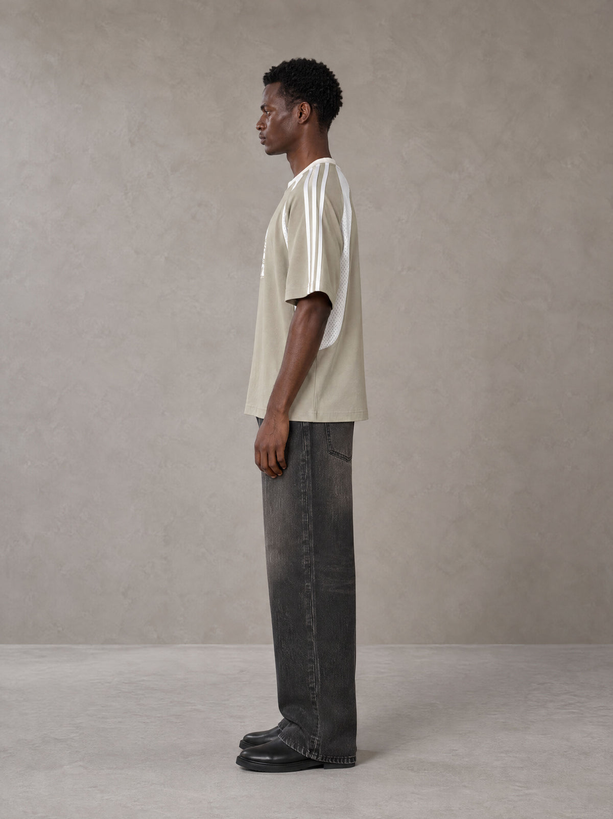 Model wearing the SM Cosmic Bloom T-shirt in Fine Sand, side profile.