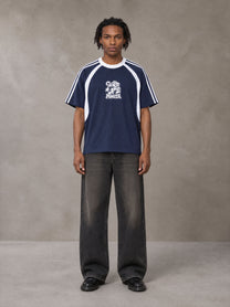 Model wearing the SM Cosmic Bloom T-shirt in Oxford Navy, front view.