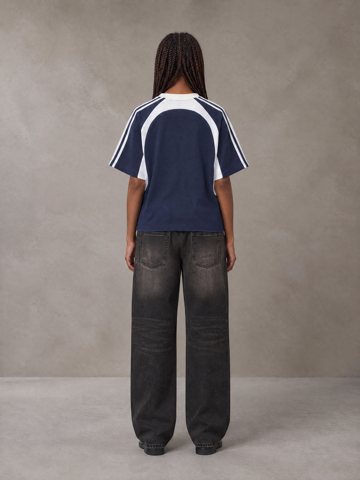 Model wearing the SM Cosmic Bloom T-shirt in Oxford Navy, rear view.