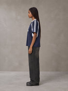 Model wearing the SM Cosmic Bloom T-shirt in Oxford Navy, side profile.
