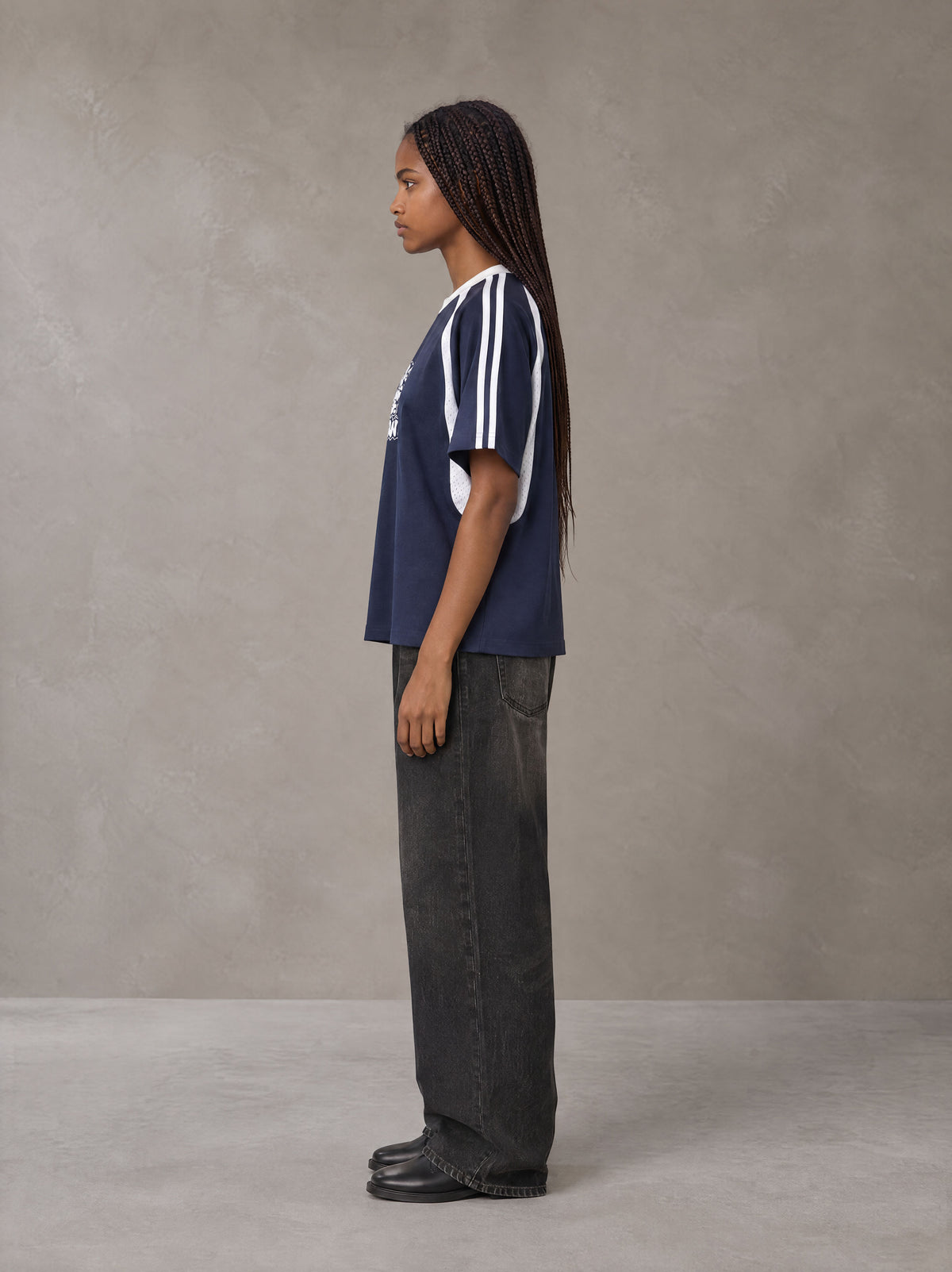 Model wearing the SM Cosmic Bloom T-shirt in Oxford Navy, side profile.