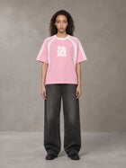 Model wearing the SM Cosmic Bloom T-shirt in Blossom, front view.