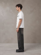 Model wearing the SM Dugout Atelier T-shirt in Lucent White, side profile.