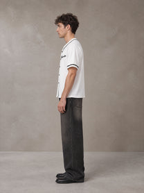 Model wearing the SM Dugout Atelier T-shirt in Lucent White, side profile.