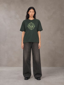 Model wearing the SM Emblem T-shirt in Dark Green, front view.