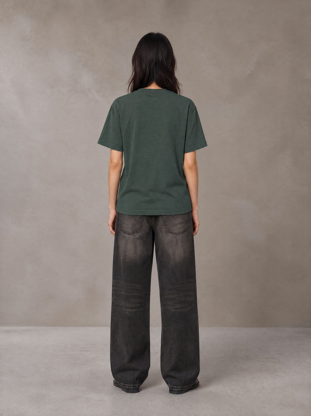 Model wearing the SM Emblem T-shirt in Dark Green, rear view.