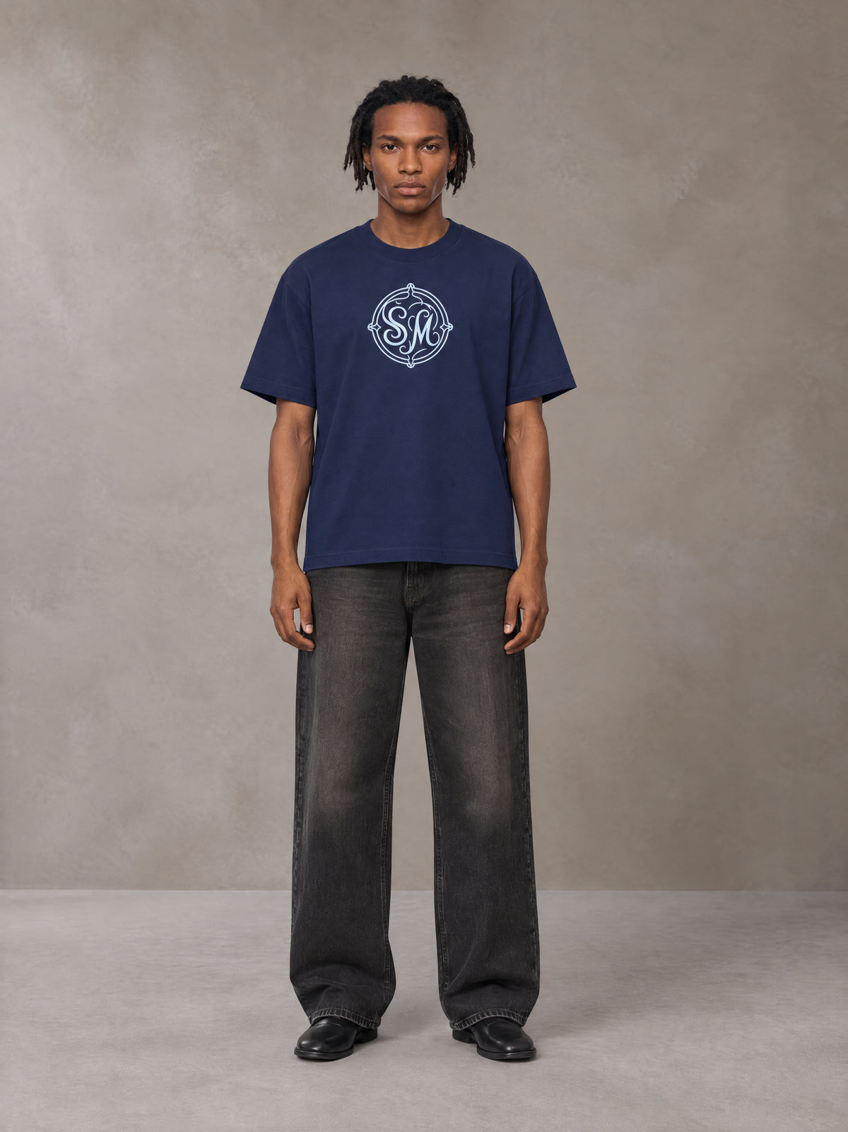Model wearing the SM Emblem T-shirt in Oxford Navy, front view.